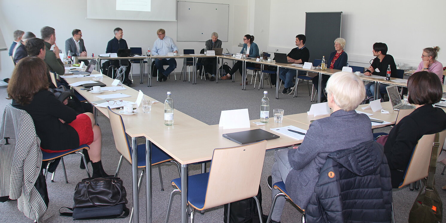 Mehrere Personen sitzen in einer Tagung.